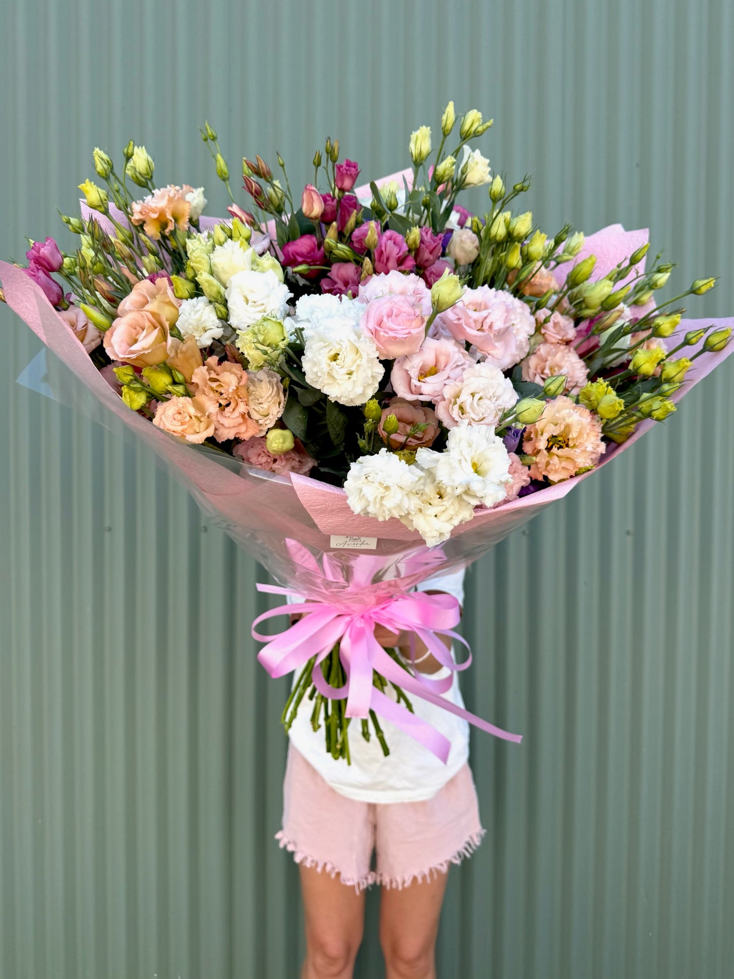 Bouquet of flowers with a pink ribbon against a green background